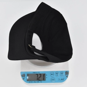 Detailed view of lightweight black sun visor weighing 72.1 grams on a digital scale