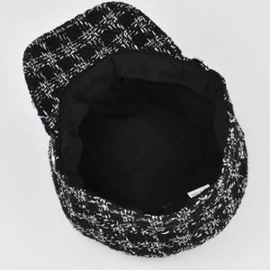 Detail of tweed newsboy cap showing inner black lining and white care label