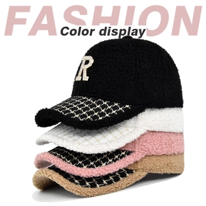 Dettaglio di cappellini in lana d'agnello con lettera R di strass in nero, bianco, rosa e marrone