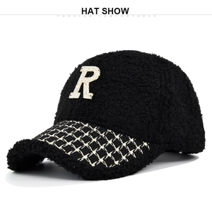 Dettaglio cappello baseball in pile teddy nero con logo R in strass e visiera a quadri