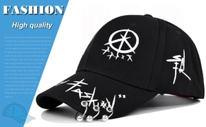 Detail of black graffiti baseball cap featuring silver rings on brim and fashion embroidery