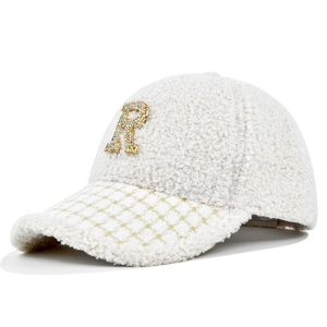 Dettaglio del cappellino bianco in pile con logo R di strass e visiera a quadri dorati