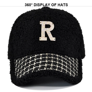Dettaglio del cappellino in pile teddy con lettera R di strass e visiera a scacchi