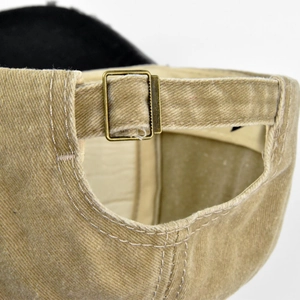 Detailed view of the vintage washed khaki cotton baseball cap with brass buckle adjustment