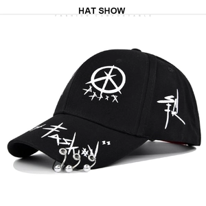 Close-up of black graffiti baseball cap with silver metal rings on the brim detail