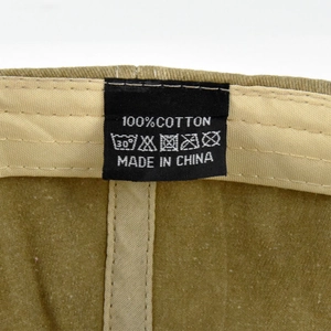 Close-up of 100% cotton care label and washing symbols on distressed baseball cap
