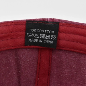Detalle de la etiqueta de lavado 100% algodón en la banda interior de la gorra color granate