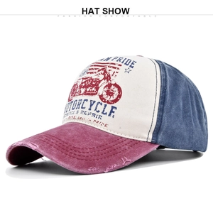 Detail of vintage washed baseball cap featuring motorcycle graffiti and distressed brim holes