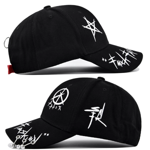 Detail view of graffiti baseball cap with metal rings and decorative red ribbon