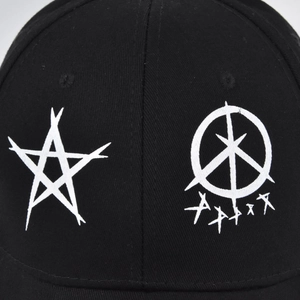 Detailed close-up of white punk star embroidery on a black cotton twill baseball cap