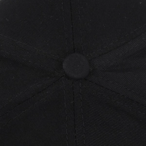 Close-up of six-panel crown stitching and top button on a black cotton baseball cap