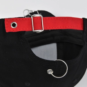 Detail of black baseball cap back with red adjustable strap and silver metal buckle