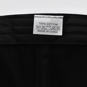 Macro view of the 100% cotton wash label and care instructions inside the baseball cap