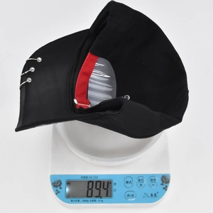 Detail shot of black graffiti baseball cap with silver rings being weighed at 89.4 grams