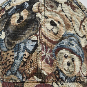 Detailopname van jacquardstof met vintage beer- en hondenpatronen op een honkbalpet