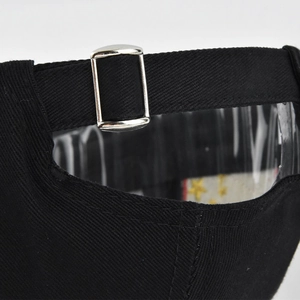 Close-up of black cotton baseball cap with adjustable metal buckle and strap detail