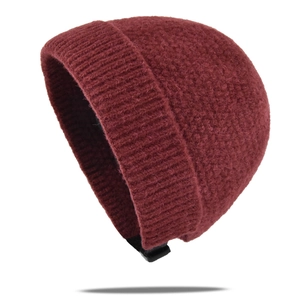 Détail du bonnet en maille bordeaux avec texture bouclée et bordure côtelée large et chaude