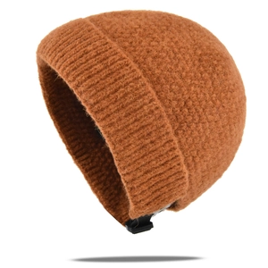 Détail d'un bonnet en tricot marron avec sangle réglable et texture en laine bouclée