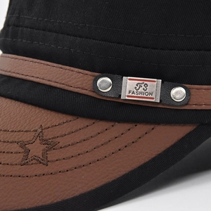 Detail of military flat cap with black canvas, brown leather brim and metal logo plate