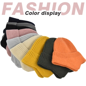 Close-up of nine colorful ribbed knit beanies in a fan-shaped arrangement for winter