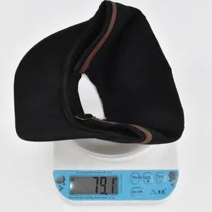 Close-up of lightweight black flat top military cap weighing 79.1g on a digital scale