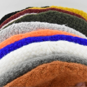 Gros plan de bonnets en tricot de mohair colorés empilés en diverses couleurs vives