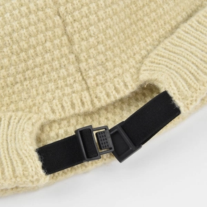 Détail de la sangle élastique noire réglable et boucle sur le bonnet tricoté beige