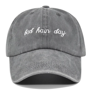Detailed front view of washed grey baseball cap with white Bad Hair Day embroidery