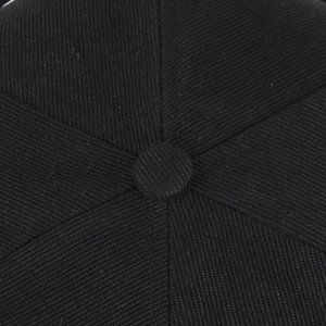 Vue détaillée du haut d'une casquette noire montrant le bouton et les coutures de qualité