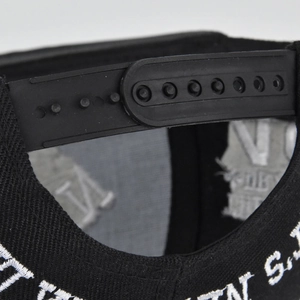 Détail d'une casquette de baseball noire avec fermeture réglable par pression en plastique