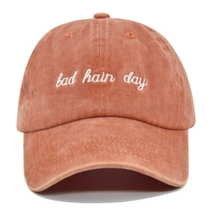 Close-up of bad hair day 3D embroidery on a vintage washed orange cotton baseball cap