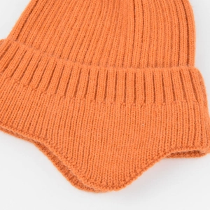 Detailed close-up of orange rib-knit beanie with earflaps showing thick texture