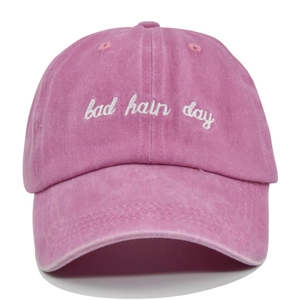 Detail of white 3D embroidery bad hair day text on washed pink vintage cotton baseball cap