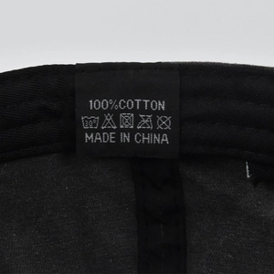 Macro shot of the 100% cotton washing label and care instructions inside a baseball cap