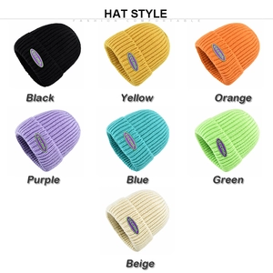 Detail view of colorful knitted beanies with ribbed texture and woven side label