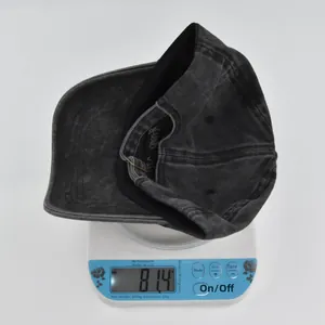 Detailed view of 81.4g weight measurement for the washed cotton baseball cap on a scale