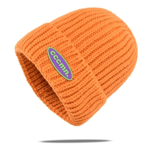 Detailed shot of heavy knit beanie featuring a purple and green rubber logo patch