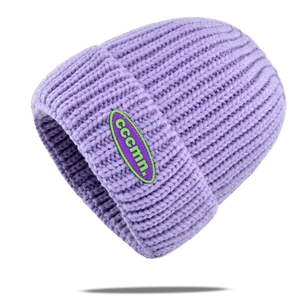 Detailed macro view of lavender purple knit beanie with woven cccmn. logo patch