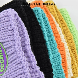 Stack of colorful thick knit beanies showing textured wool finish and fashion labels