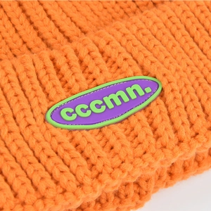 Orange ribbed knit beanie with purple brand patch for autumn winter warmth