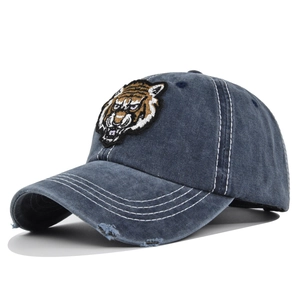 Detailed view of 3D tiger embroidery and distressed brim on washed denim baseball cap