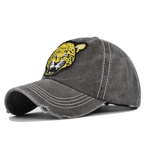 Detail of vintage washed baseball cap with yellow leopard embroidery and distressed brim