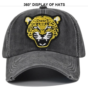 Close-up of leopard embroidery and distressed details on a washed gray baseball cap