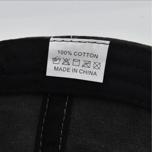 Detail view of the 100% cotton wash label and internal stitching on the baseball cap
