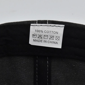 Detail shot of the 100% cotton wash label and inner stitching on a black baseball cap