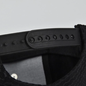 Detail des verstellbaren Snapback-Verschlusses und des Mesh-Gewebes der schwarzen Kappe