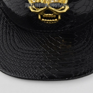Cappello snapback in finta pelle di serpente nera con teschio dorato in strass