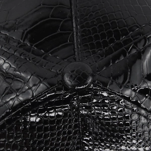 Dettaglio macro della texture coccodrillo nero lucido in ecopelle sul cappello hip-hop