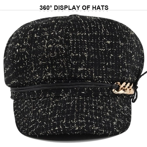 Détail d'une casquette gavroche noire avec fil métallique doré et chaîne en or