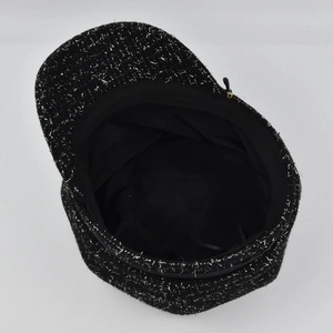 Vue détaillée d'une casquette gavroche en tweed noir avec fil doré et doublure intérieure